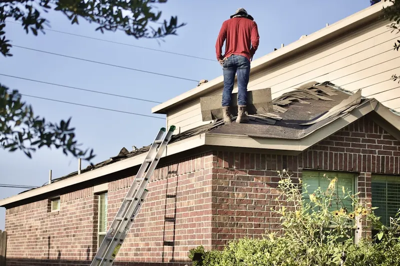 Professional roofer working on a residential roof in Denton
